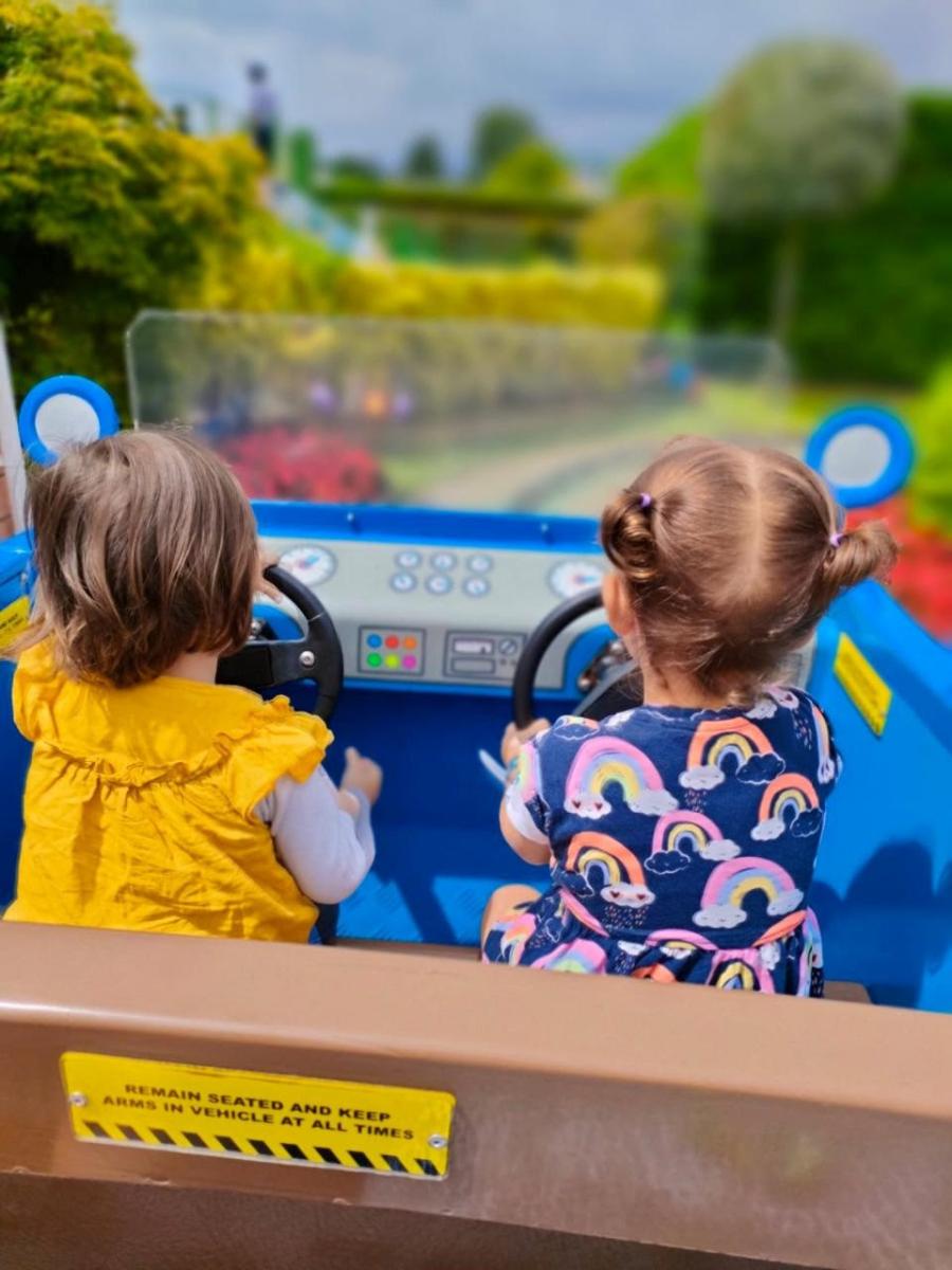 Two children driving a toy car
