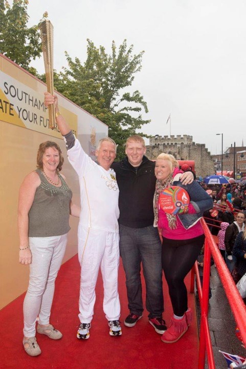 Jim Whitmarsh holding the 2012 olympic torch, with his family